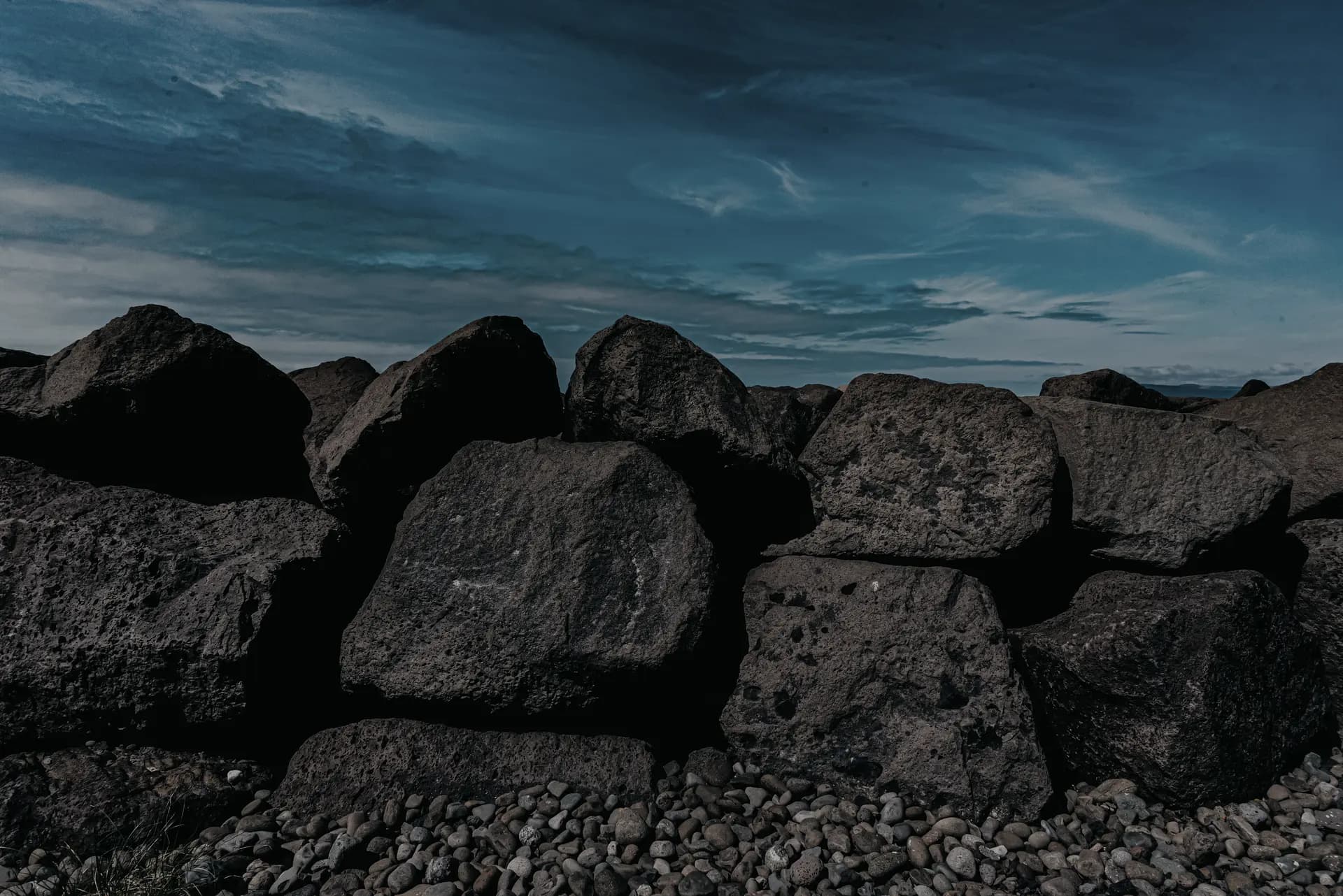 Armour rock boulders stacked along a coastal seawall