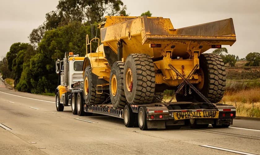 Heavy equipment transporter carrying construction machinery